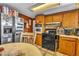 Functional kitchen featuring stainless steel refrigerator, wood cabinetry, and an oven range at 5125 Hallet Dr, Las Vegas, NV 89122