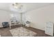 Bright bedroom with desk, chairs, mini fridge, and modern ceiling fan at 513 Rafkin Pl, Henderson, NV 89052