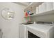 Bright laundry room features modern washer and dryer, storage shelves and white walls at 513 Rafkin Pl, Henderson, NV 89052