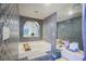 Stylish bathroom featuring tiled walls, a soaking tub and unique architectural details at 5323 Taravilla Cir, Las Vegas, NV 89146