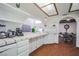 Open-concept kitchen with white cabinets, tiled counters, and a view into the dining room at 5323 Taravilla Cir, Las Vegas, NV 89146