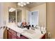 Bathroom featuring double sinks, a large mirror, and a combined shower-tub with glass door at 5850 Sonoma Station Ave, Las Vegas, NV 89139