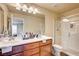 Bright bathroom featuring double sinks, wood cabinets, and a glass-enclosed shower at 5850 Sonoma Station Ave, Las Vegas, NV 89139