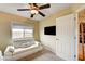 Bedroom with ceiling fan, flat screen tv, a window, and a white futon at 5850 Sonoma Station Ave, Las Vegas, NV 89139