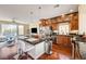 Open-concept kitchen featuring hardwood floors, a granite island with seating, and stainless steel appliances at 5850 Sonoma Station Ave, Las Vegas, NV 89139