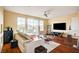 Cozy living room with hardwood floors, neutral color palette, large windows, and an entertainment center at 5850 Sonoma Station Ave, Las Vegas, NV 89139