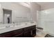 Well-lit bathroom with double sinks, modern fixtures, and a glass-enclosed shower stall at 6156 Ava Ridge Ave, Las Vegas, NV 89141