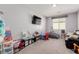 Carpeted playroom with window, TV and a variety of toys and play equipment at 6156 Ava Ridge Ave, Las Vegas, NV 89141