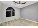 Bright bedroom features a ceiling fan, a large arched window and wood-look flooring at 62 Incline Village Ct, Henderson, NV 89074