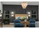 Modern main bedroom features paneled accent wall, stylish chandelier, and cozy blue chairs at 62 Incline Village Ct, Henderson, NV 89074