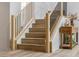 Bright staircase with wood steps, black metal railings, and adjacent wooden table featuring plants and ceramic vases at 62 Incline Village Ct, Henderson, NV 89074