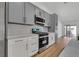 Well-lit kitchen showcasing gray and white cabinets, stainless steel appliances, and light countertops at 6664 Rutgers Dr, Las Vegas, NV 89156