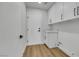 Simple laundry room with wood-look flooring and white cabinets at 6664 Rutgers Dr, Las Vegas, NV 89156