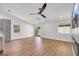 Spacious living room with sleek ceiling fan, wood floors, and sliding glass door leading to the backyard at 6664 Rutgers Dr, Las Vegas, NV 89156