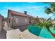 Backyard pool with a red tile roof house, tropical landscaping, and a large concrete patio in a desert environment at 6664 Rutgers Dr, Las Vegas, NV 89156