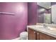 Small bathroom features a purple accent wall, vanity with sink, toilet, and shower stall with glass door at 6687 Higger Tor Ave, Las Vegas, NV 89139