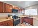 This kitchen boasts stainless steel appliances, wooden cabinets, laminate countertops, and a view out the window at 6687 Higger Tor Ave, Las Vegas, NV 89139