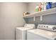 Small laundry room with a white washer and dryer, plus a shelf to keep cleaning supplies at 6687 Higger Tor Ave, Las Vegas, NV 89139