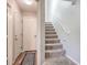 Carpeted staircase with white walls and trim near a doorway, showcasing the home's interior design at 6687 Higger Tor Ave, Las Vegas, NV 89139