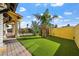 Lush backyard featuring artificial grass, a well landscaped perimeter and covered patio at 6760 Hinson St, Las Vegas, NV 89118