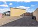 Exterior shot of a home's backyard, showcasing the gravel, fence and patio area at 6760 Hinson St, Las Vegas, NV 89118