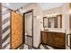 Charming bathroom with a unique tile floor, rustic wood vanity, and a walk-in shower at 6760 Hinson St, Las Vegas, NV 89118