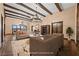 Spacious living room with wood beam ceilings, hardwood floors, a decorative chandelier and neutral-colored furniture at 6760 Hinson St, Las Vegas, NV 89118