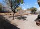 Spacious backyard featuring a brick retaining wall, mature trees, and a gravel landscape at 710 Strawberry Pl, Henderson, NV 89002