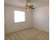 This bedroom boasts neutral carpet, a ceiling fan, and a window for natural light at 710 Strawberry Pl, Henderson, NV 89002