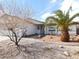 Landscaped front exterior with stucco, a charming pineapple tree, and a green lawn at 710 Strawberry Pl, Henderson, NV 89002