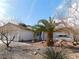 Charming single-story home with desert landscaping, including a palm tree and rock features in the front yard at 710 Strawberry Pl, Henderson, NV 89002