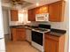 Well-maintained kitchen featuring wooden cabinets, granite countertops, and modern white appliances at 710 Strawberry Pl, Henderson, NV 89002