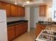 Traditional kitchen with wooden cabinets, granite counters, and a white refrigerator and gas stove at 710 Strawberry Pl, Henderson, NV 89002