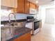 Kitchen sink with wood cabinets and white appliances, next to an open dining area at 710 Strawberry Pl, Henderson, NV 89002