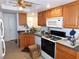 Functional kitchen featuring tile flooring, oak cabinetry, black countertops, and modern appliances at 710 Strawberry Pl, Henderson, NV 89002