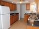 Traditional kitchen with wooden cabinets, granite counters, and a white refrigerator and gas stove at 710 Strawberry Pl, Henderson, NV 89002