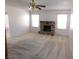 Open living room with carpet, a brick fireplace, and a ceiling fan with light fixture at 710 Strawberry Pl, Henderson, NV 89002