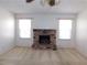 Bright living room with neutral carpet and a brick fireplace between two windows at 710 Strawberry Pl, Henderson, NV 89002