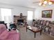 Cozy living room with a brick fireplace, plush seating, and natural light from large windows at 710 Strawberry Pl, Henderson, NV 89002