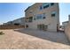 View of the home's facade from the backyard featuring a balcony and sliding glass doors to the patio at 7180 Grace Estate Ave, Las Vegas, NV 89113