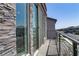 View of the neighborhood from the balcony with stone facade, black railings, and large sliding glass doors at 7180 Grace Estate Ave, Las Vegas, NV 89113