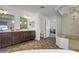 Well-lit bathroom features a luxurious shower, dual vanity, and neutral tile flooring at 7180 Grace Estate Ave, Las Vegas, NV 89113