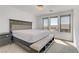 Bedroom showcasing a bed with a padded headboard, a bench, and natural light from three windows at 7180 Grace Estate Ave, Las Vegas, NV 89113