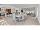 Open-concept dining room with a marble top dining table, kitchen island with barstool seating and access to the living room at 7180 Grace Estate Ave, Las Vegas, NV 89113