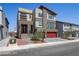 Contemporary home with a red two-car garage, stone accents, and landscaped front yard at 7180 Grace Estate Ave, Las Vegas, NV 89113