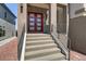 Inviting front entrance with a red double door, stone accents, and sleek railings at 7180 Grace Estate Ave, Las Vegas, NV 89113