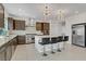 Modern kitchen featuring stainless steel appliances, a kitchen island with barstool seating, and quartz countertops at 7180 Grace Estate Ave, Las Vegas, NV 89113