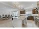 Open concept kitchen with stainless steel appliances, a large island with bar stool seating and view of the dining room at 7180 Grace Estate Ave, Las Vegas, NV 89113