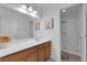 Well-lit bathroom with a single sink vanity, decorative art, and a walk-in shower at 7707 W Diablo Dr, Las Vegas, NV 89113