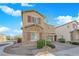 Charming two-story home features a stone facade, neutral paint, red shutters, desert landscaping, and a paver driveway at 7707 W Diablo Dr, Las Vegas, NV 89113